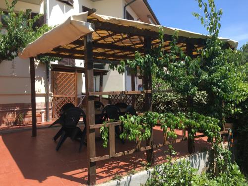 un patio con pérgola de madera y algunas plantas en Appartamento Bellavista, en Castiglioncello