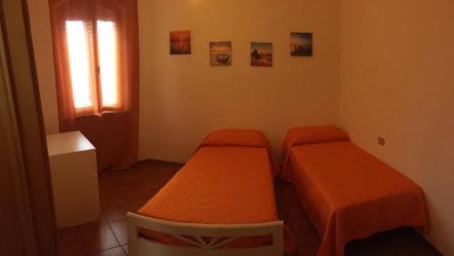 2 camas en una habitación pequeña con ventana en Appartamento Bellavista, en Castiglioncello