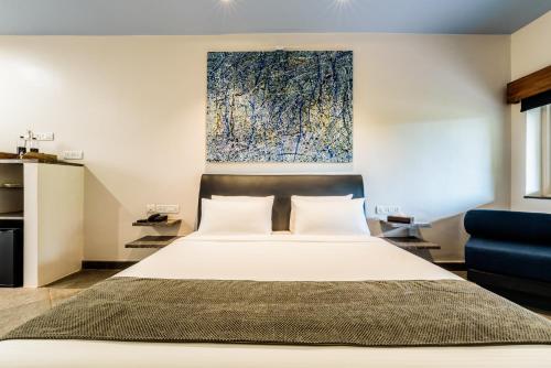 a bedroom with a bed and a painting on the wall at Argo by Trance in Dabolim