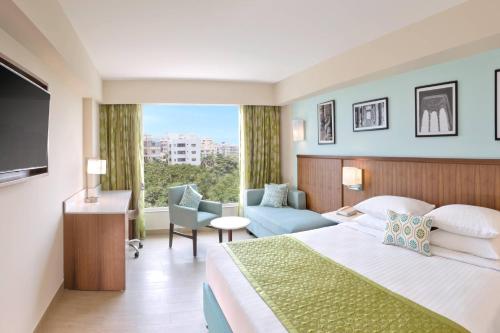 ヴィシャカパトナムにあるFairfield by Marriott Visakhapatnamのベッドと大きな窓が備わるホテルルームです。
