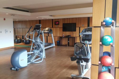 a gym with exercise equipment and a flat screen tv at Fairfield by Marriott Visakhapatnam in Visakhapatnam