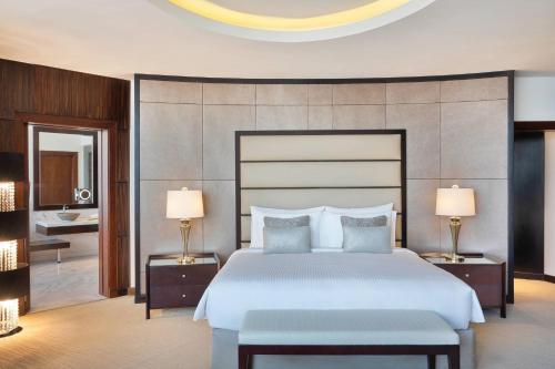 a bedroom with a large bed and two lamps at JW Marriott Hotel Riyadh in Riyadh