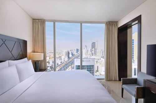 利雅德的住宿－JW Marriott Hotel Riyadh，一间卧室设有一张大床和一个大窗户