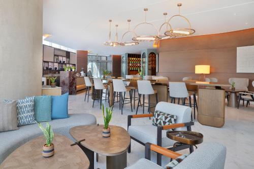 a lobby with chairs and tables and a restaurant at JW Marriott Hotel Riyadh in Riyadh