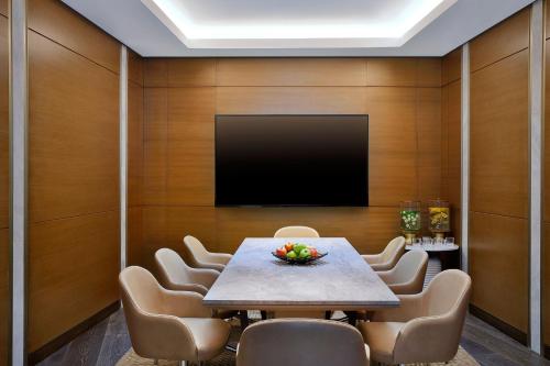 a conference room with a table and chairs and a flat screen tv at JW Marriott Hotel Riyadh in Riyadh
