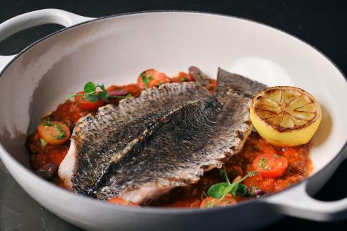 a pan filled with fish and vegetables with a lemon at JW Marriott Hotel Riyadh in Riyadh
