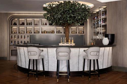 a bar in a hotel with stools at a counter at JW Marriott Hotel Riyadh in Riyadh