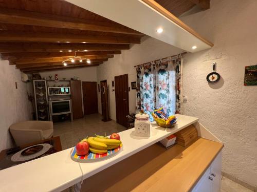 a kitchen with a counter with a plate of bananas at DIMIS swimming pool small villa in Eretria