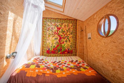 a bedroom with a bed with a painting on the wall at Natura Lodge in Barjac
