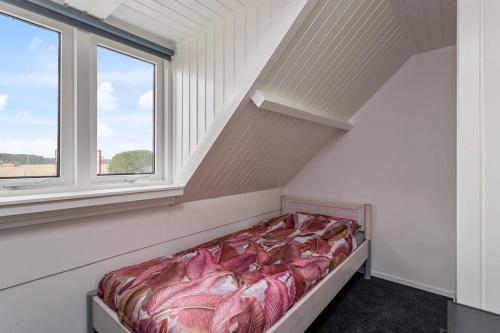 1 cama en una habitación con 2 ventanas en Vrijstaande woning, grote tuin., en Waterlandkerkje