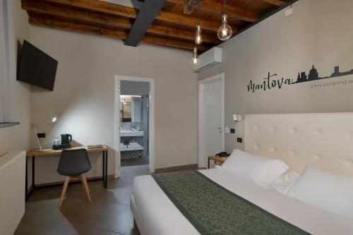 a bedroom with a bed and a desk and a tv at Bonacolsi Collection, MantegnaHotels in Mantova