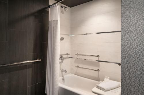 a bathroom with a tub and a toilet and a sink at The Clancy, Autograph Collection in San Francisco