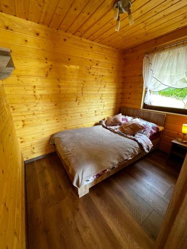 a bedroom with a bed in a wooden room at Domek Bogdanówka in Pisarzowa