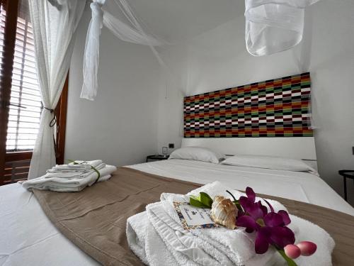 a bedroom with a bed with towels and flowers on it at sicily home casa vacanze con piscina in San Vito lo Capo