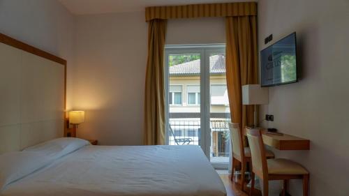 a hotel room with a bed and a window at Hotel Mavino in Sirmione