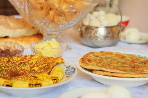 una mesa cubierta con platos de comida y pasteles en House of Tengi Craftswomen 