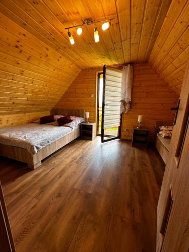 a bedroom with a bed in a wooden cabin at Domek Bogdanówka in Pisarzowa