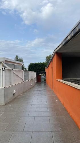an empty walkway next to an orange building at Work and Rest Away From Home in Paterna