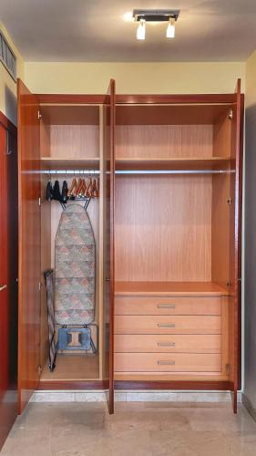 a walk in closet with wooden cabinets and shelves at Work and Rest Away From Home in Paterna