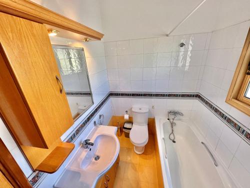 ein Badezimmer mit einer Badewanne, einem WC und einem Waschbecken in der Unterkunft Lovely Pool Villa in Pyla in Pyla