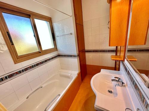 a bathroom with a tub and a sink and a window at Lovely Pool Villa in Pyla in Pyla