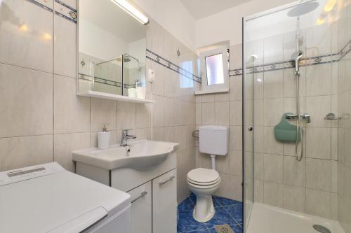 y baño con aseo, lavabo y ducha. en Apartmani Raić, en Mali Lošinj
