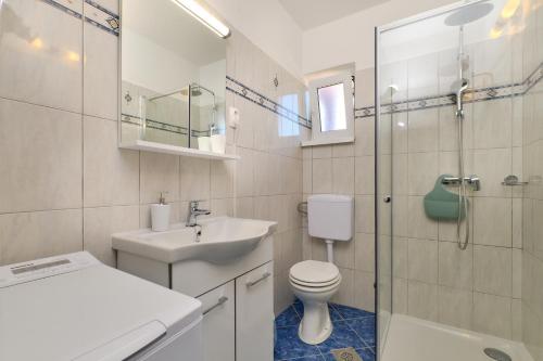 a bathroom with a toilet and a sink and a shower at Apartmani Raić in Mali Lošinj