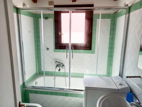 baño verde y blanco con ducha y lavamanos en Stintino Appartamento Country Bagaglino - Anna -, en Stintino