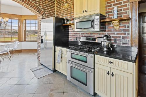 a kitchen with a stove and a microwave at Grand Historic 8BR 6 5BA Mansion Waterfront Decks in Atlantic City