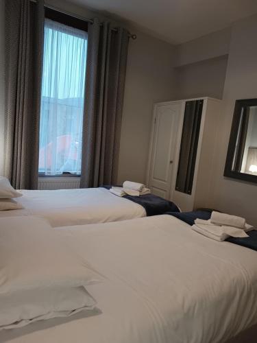two beds in a hotel room with a window at Westgate Hotel in Oxford