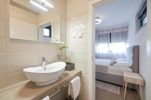 a bathroom with a sink and a bed at Apartments Mato in Zadar