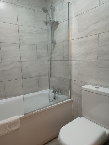a bathroom with a shower and a toilet and a tub at Westgate Hotel in Oxford