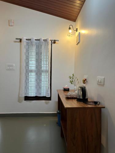 a kitchen with a wooden counter and a window at THE MASCARA - Home stay @ Coorg in Kushālnagar