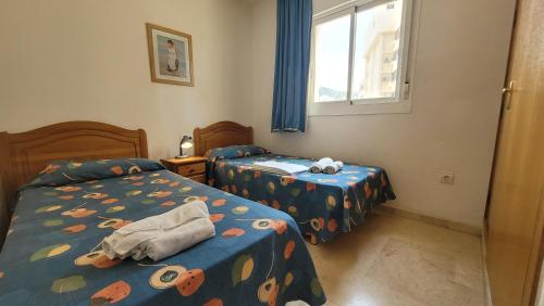 een slaapkamer met 2 bedden en een raam bij Gemelos 22-Fincas Benidorm in Benidorm