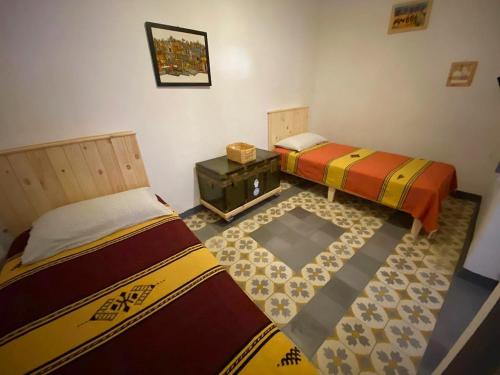 a room with two beds and a table in it at Vallparadis Pension Familiar" FIRDAUS" in Chefchaouene