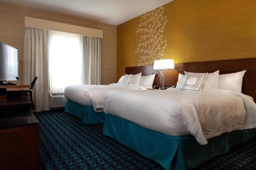 a hotel room with two beds and a television at Fairfield Inn & Suites by Marriott Lethbridge in Lethbridge