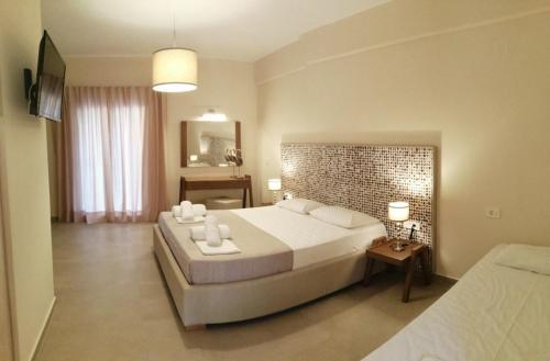 a large bedroom with a large bed and a mirror at Dafni studios no8 in Parga