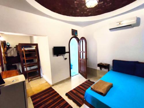 a living room with a blue bed and a room with a ceiling at Ghazala Boutique Hotel Dahab in Dahab