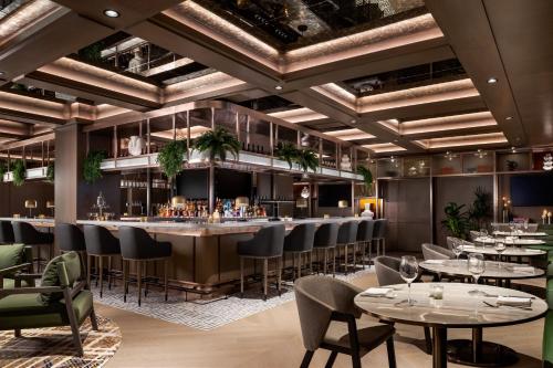 a restaurant with tables and chairs and a bar at Sheraton Centre Toronto Hotel in Toronto