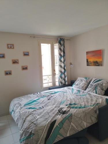 un dormitorio con una cama y una ventana en Les Chatelaines, en Hyères