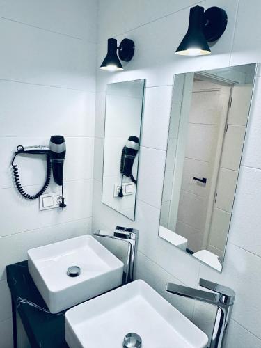 a bathroom with a white sink and a mirror at Apartamentos Noja Playa in Noja