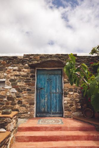 a blue door on the side of a stone building at Castria studios in Kionia