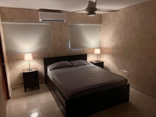 ein Schlafzimmer mit einem Bett und zwei Tischen mit Lampen in der Unterkunft Serenity III in La Estrella
