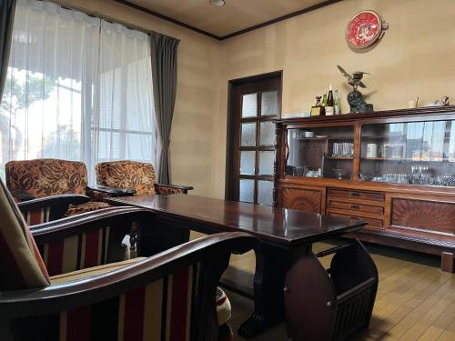 une salle à manger avec une table et des chaises en bois dans l'établissement みんなのひみつきち YuToRi 遊人里, à Higashihiroshima