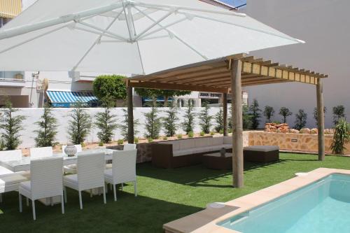 a patio with an umbrella and a table and chairs at Can Mossènyer in San Antonio