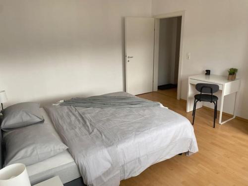a bedroom with a bed and a desk with a chair at FarawayHomes Studio Leoben #A11 in Leoben