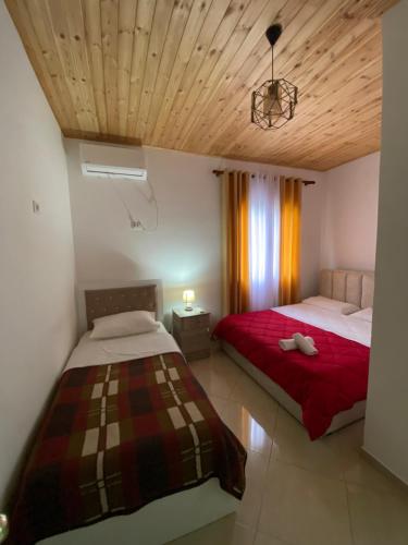 a bedroom with two beds in a room with wooden ceilings at Lugina e Komanit in Koman