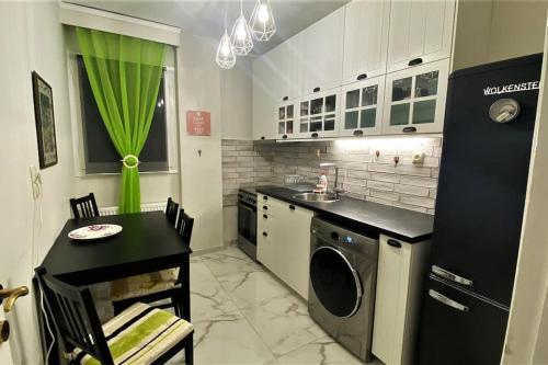 een keuken met een wasmachine, een tafel en een wastafel bij Iris' Apartment in Thessaloniki