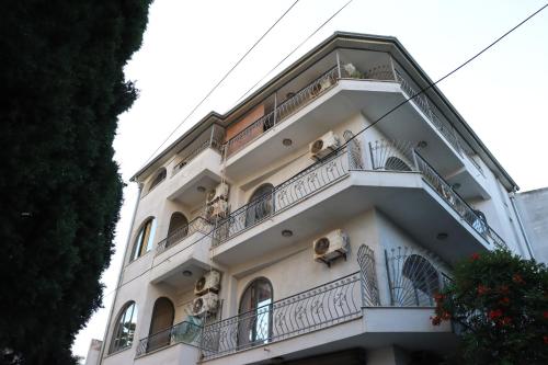 a tall white building with people on the balconies at ~Villa Gloria~ in Durrës