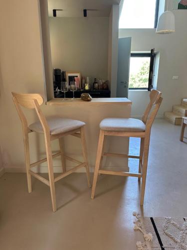 a kitchen with two wooden chairs and a counter at La casa di Zoe-ARTANDTRAVEL in Montefiascone